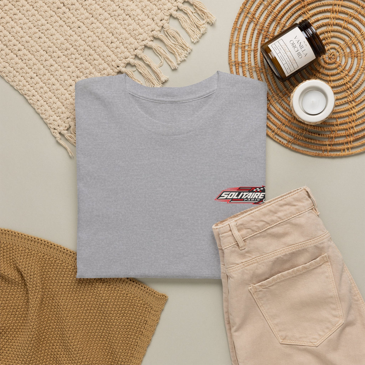 Grey Solitaire Paris logo t-shirt laid flat with beige pants and decor